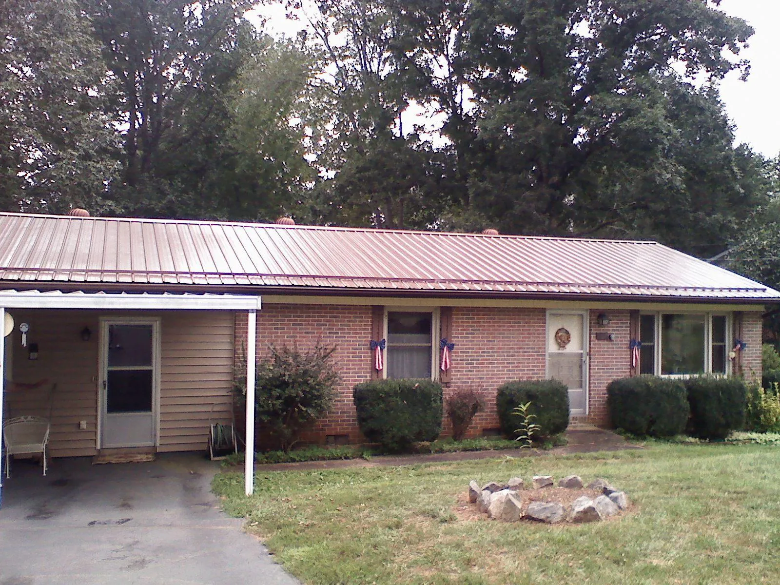 Bronze metal roof and carport on a brick ranch home — Roof Repair work by our crew in Castle Hayne