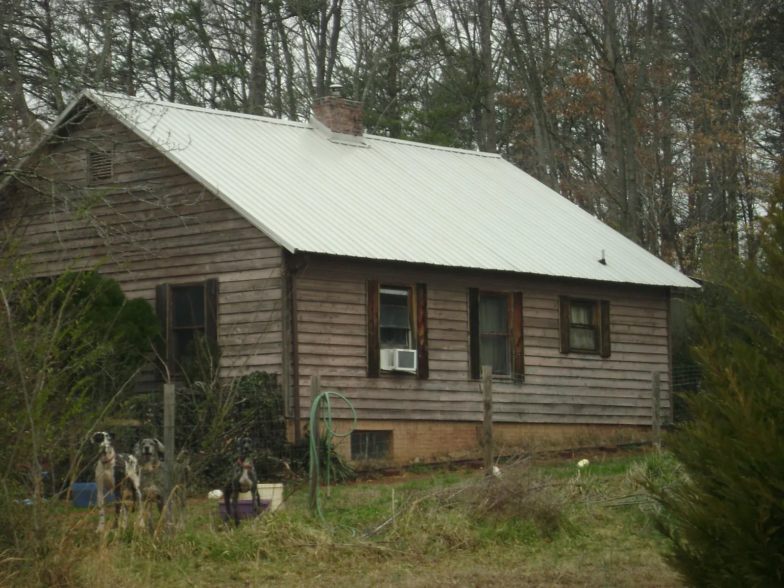 White metal roof on an old wood sided farmhouse, from a Metal Roof Installation job in Castle Hayne